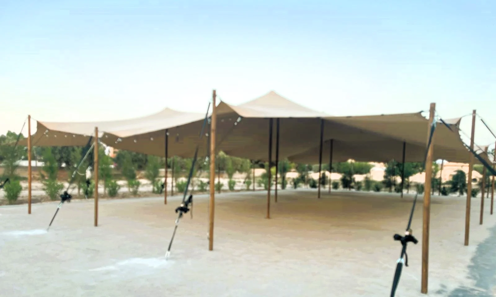 Carpa Tensada de Vanguardia beige con sus formas curvas sobre arena